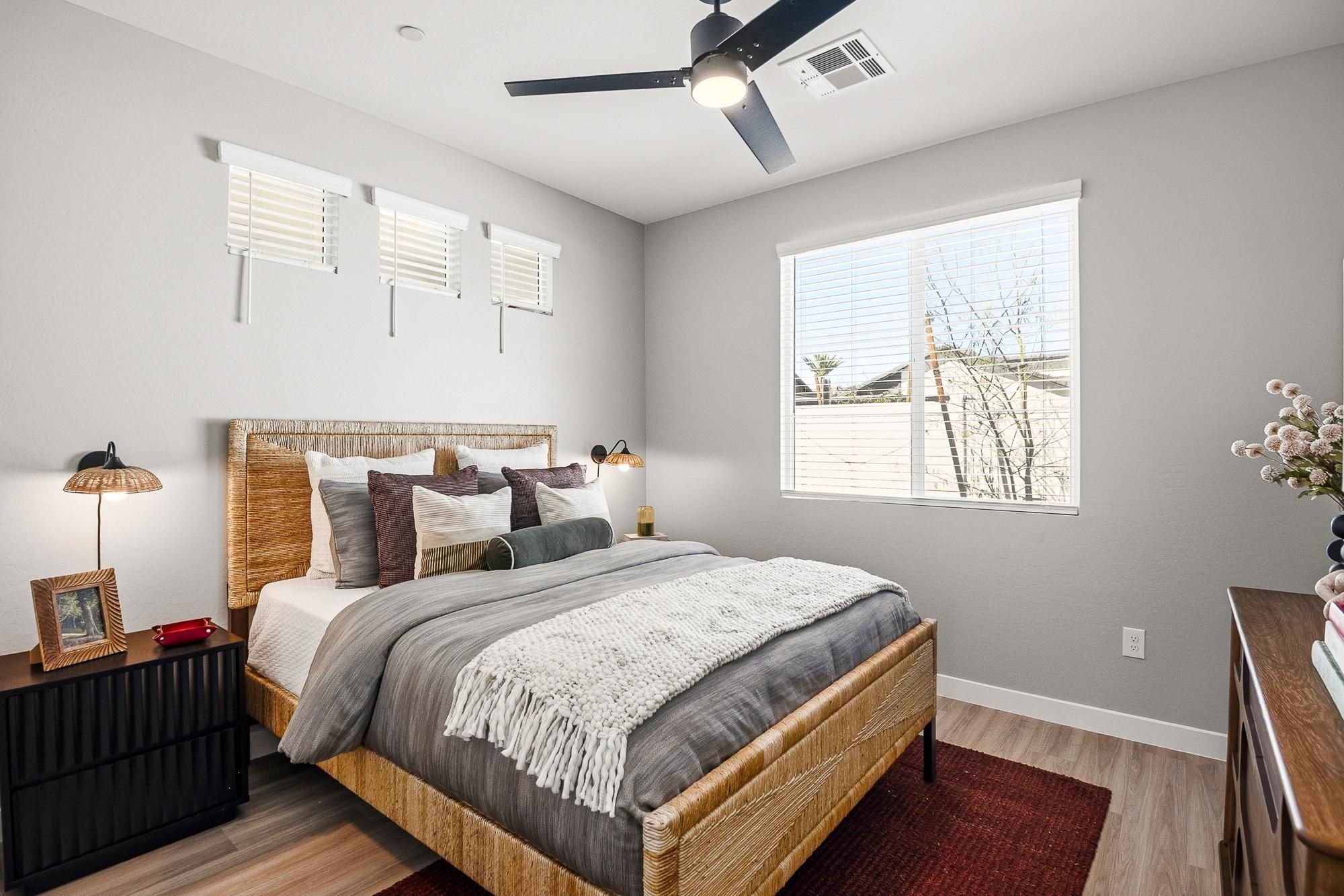 Sonita apartments Modern bedroom with a wooden bed, neutral bedding, nightstands, and large window letting in natural light.