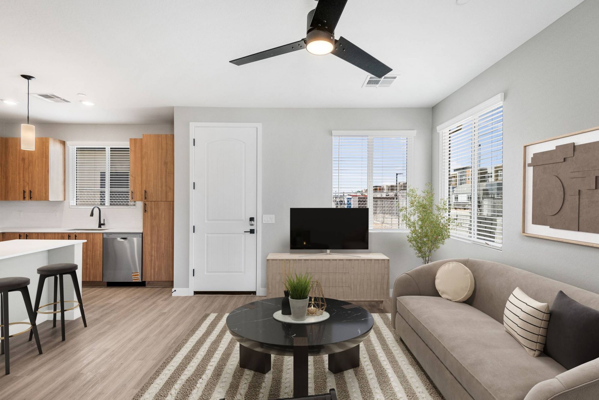 Sonita Modern living room with a sofa, coffee table, TV, and kitchen in a bright, minimalist open space.