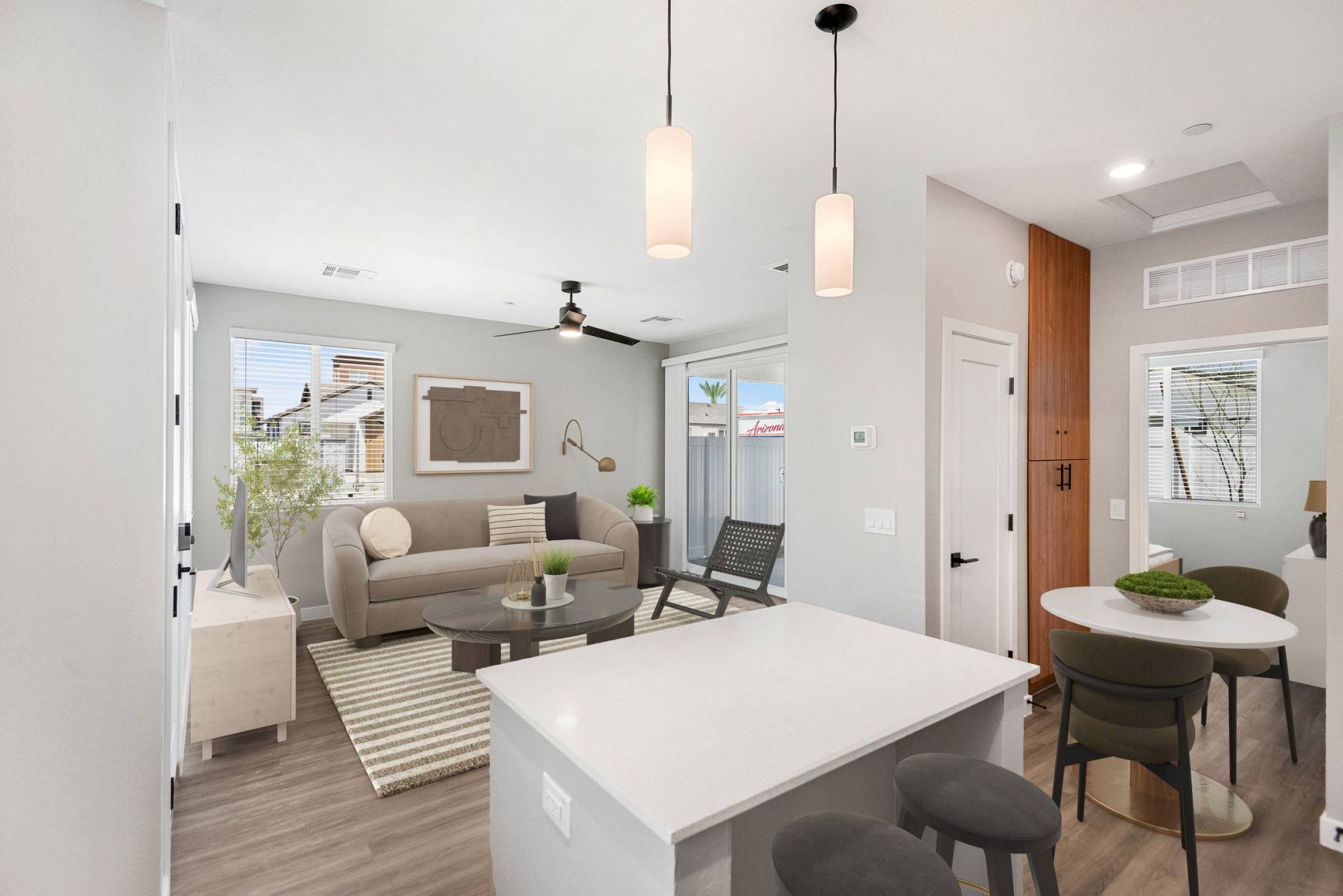 Sonita Modern open-concept living space with kitchen island, dining area, sofa, and large windows letting in light.