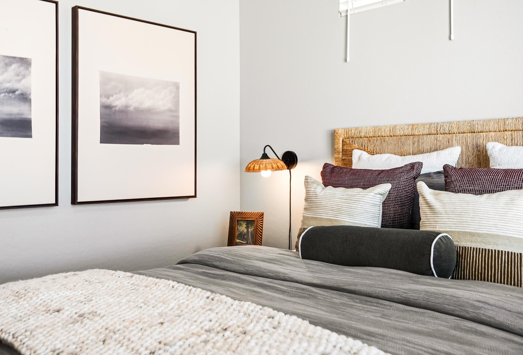 Sonita apartments Modern bedroom with a neatly made bed, cozy pillows, bedside lamp, and framed art on the wall.
